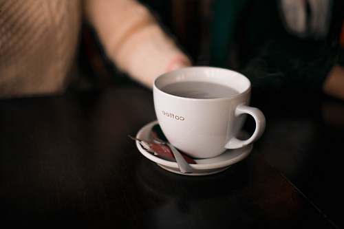 coffee cup shallow focus photography of coffee cup saucer